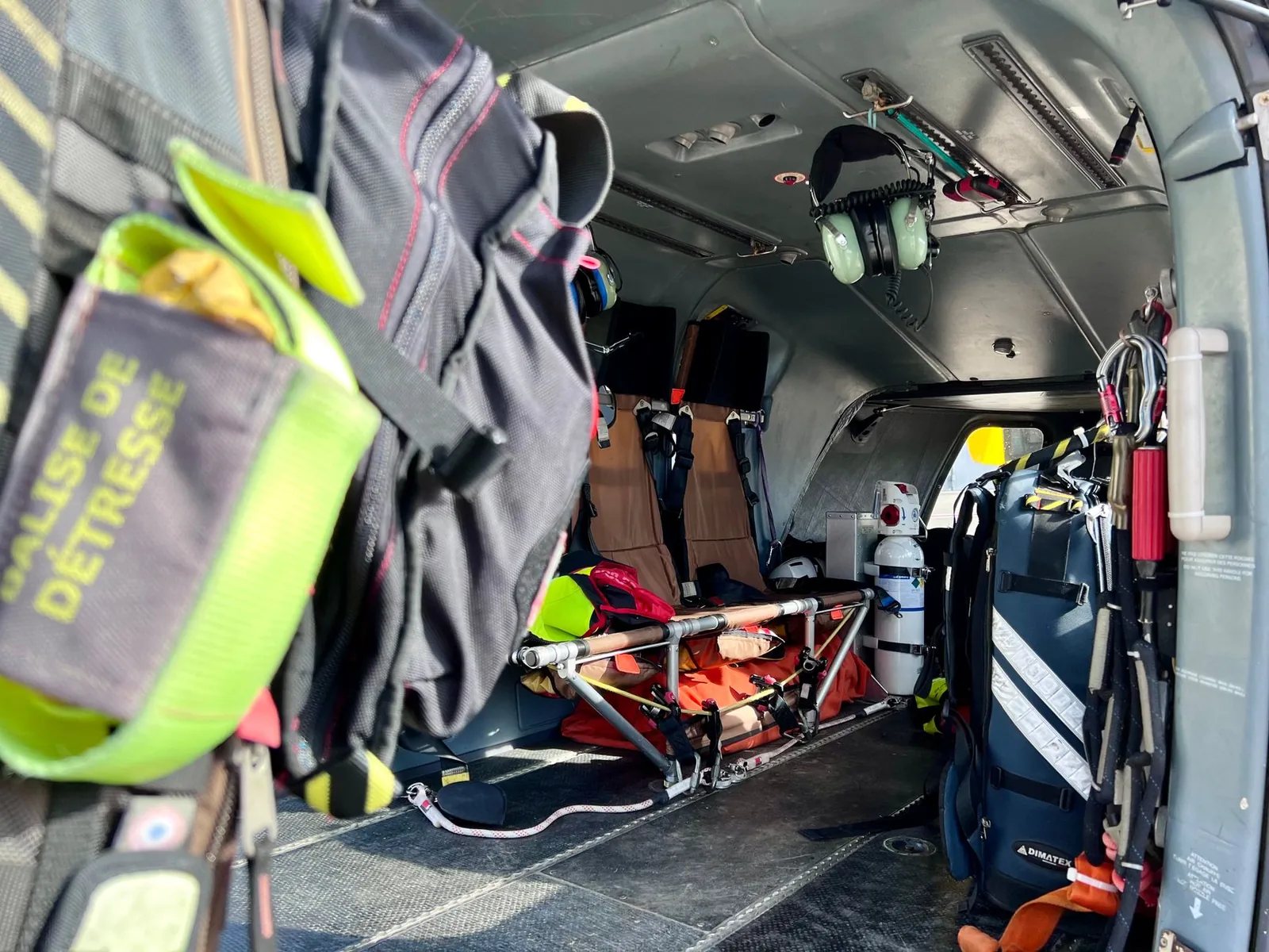 Cabine d'un hélicoptère de secours français : civière, bouteille d'oxygène et balise de détresse