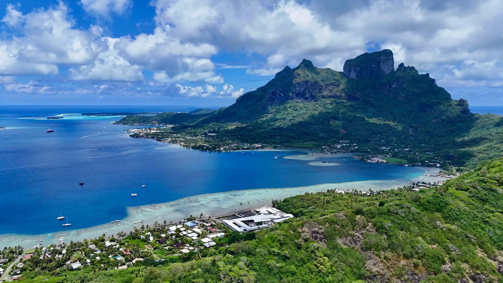 Lagon de Bora Bora et mont Otemanu sous un ciel de belles éclaircies, végétation encore verte en début de saison sèche