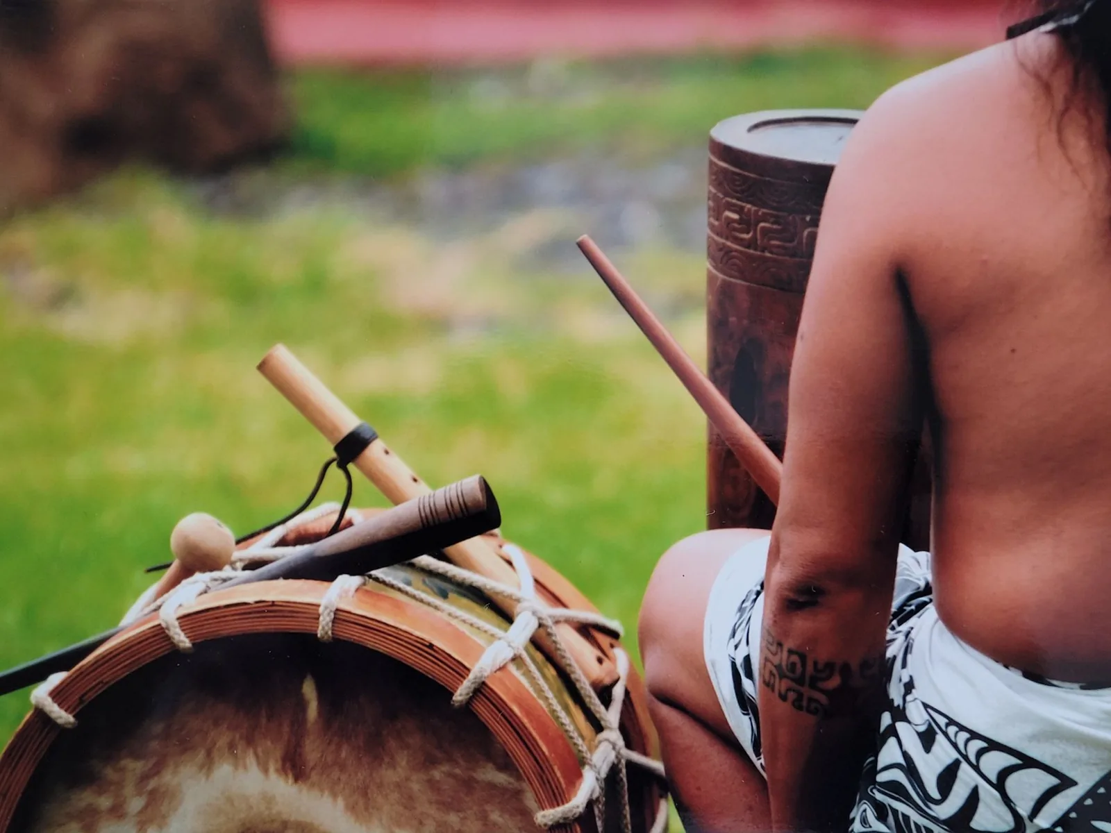 Percussions polynésiennes, pahu sculpté et tambour à membrane avec leurs baguettes