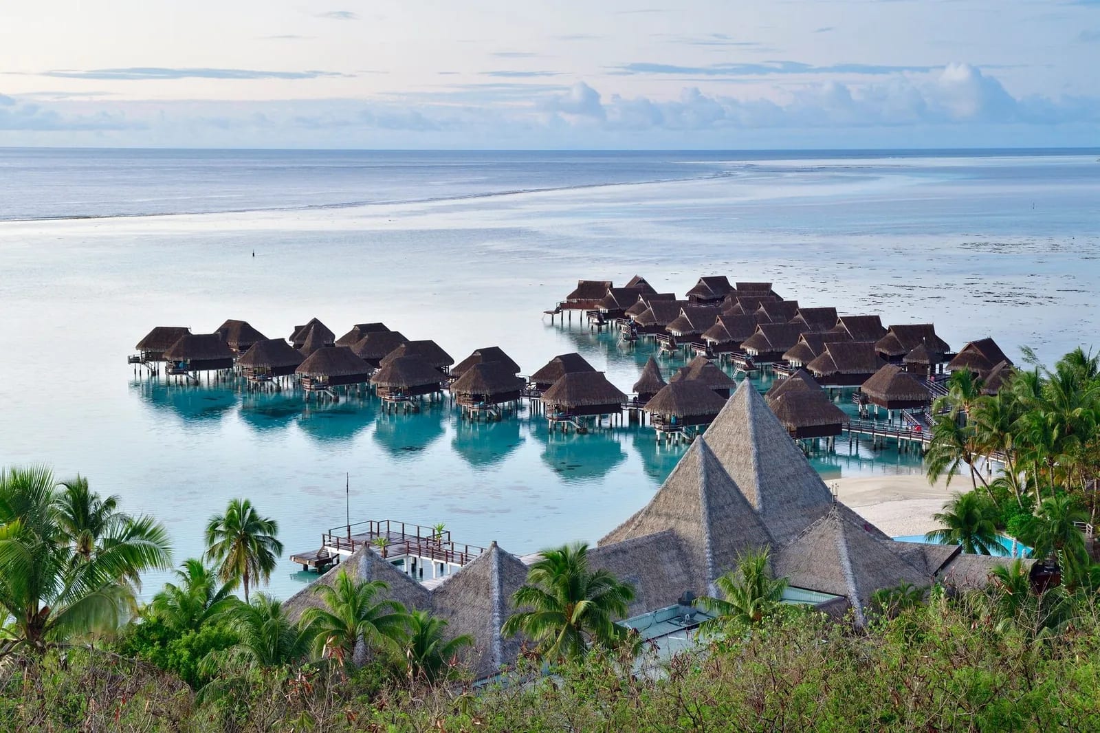 Bungalows sur pilotis d'un resort de Moorea au-dessus du lagon turquoise, Polynésie française