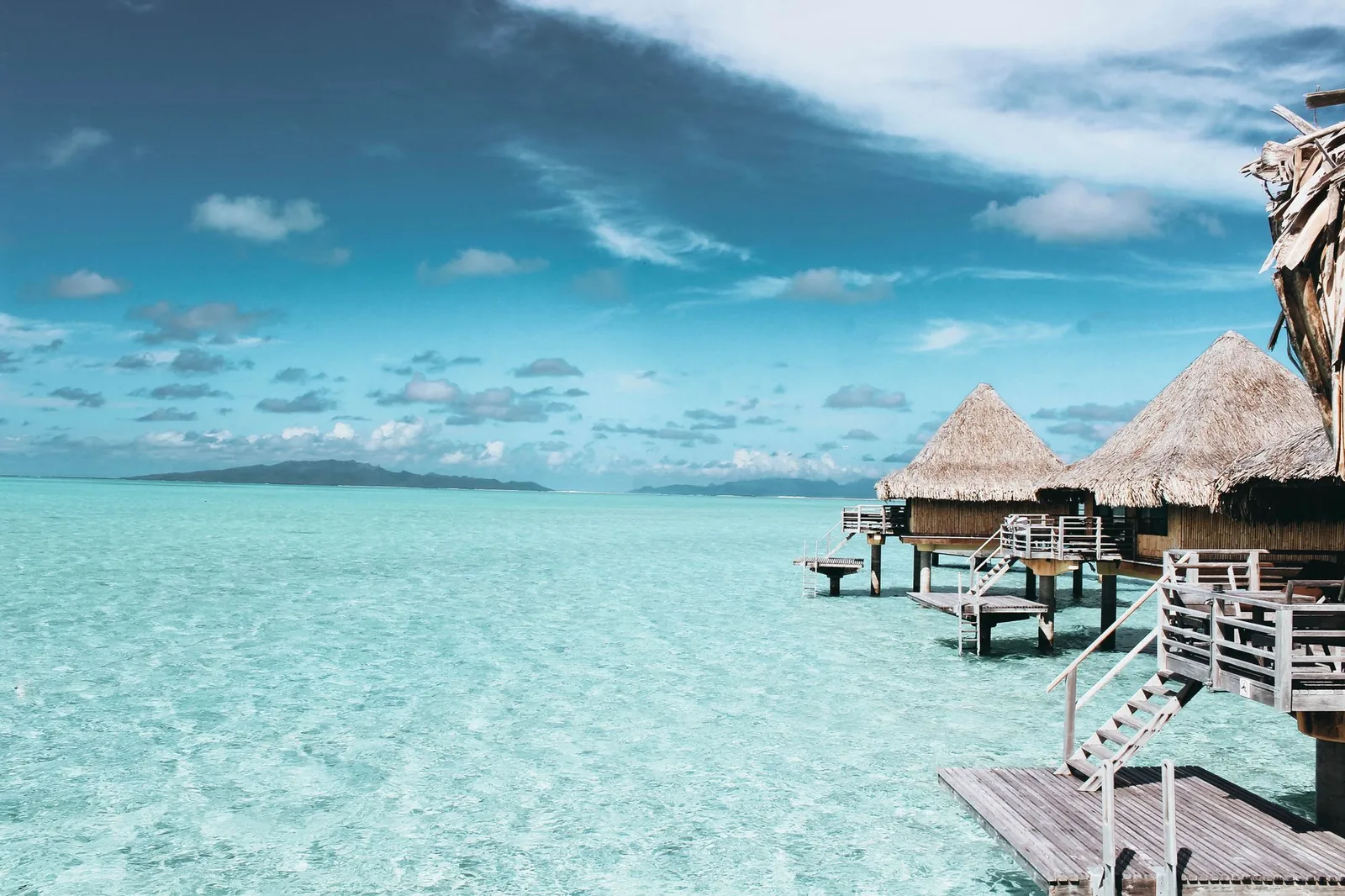 Terrasse d'un bungalow sur pilotis au-dessus d'un lagon turquoise