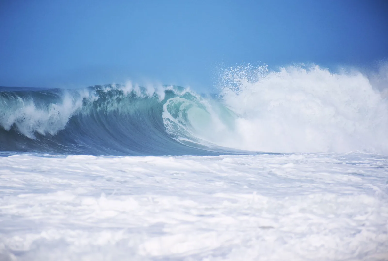 Vague épaisse déferlant sur un récif, comme à Teahupo'o sur la presqu'île de Tahiti