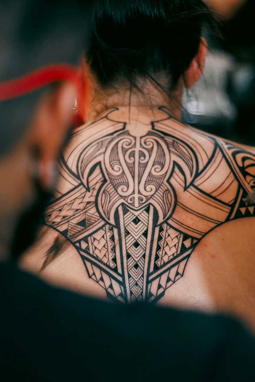 Tatouage polynésien féminin sur le dos et la nuque d'une femme