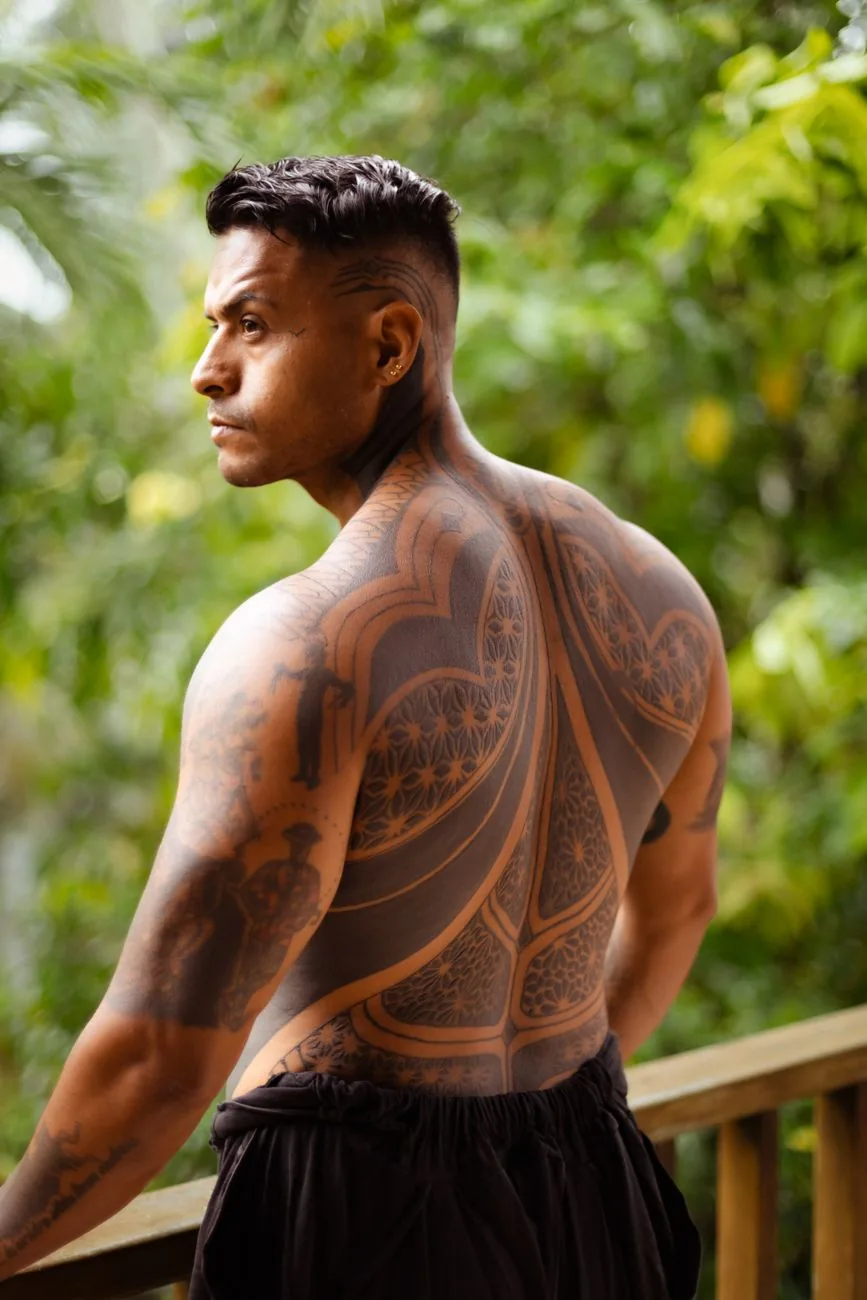 Tatouage polynésien masculin couvrant le dos et l'épaule d'un homme